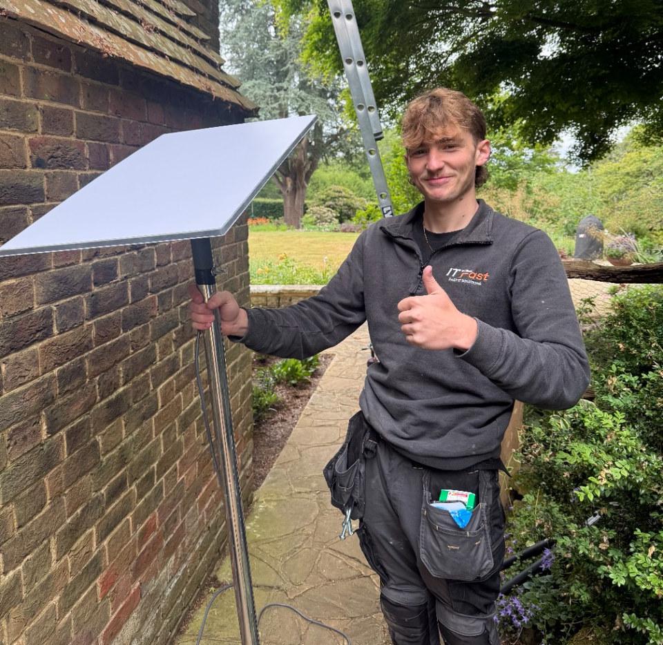 Berkshire WiFi engineer Kyle holding a Starlink dish on a pole ready for installation