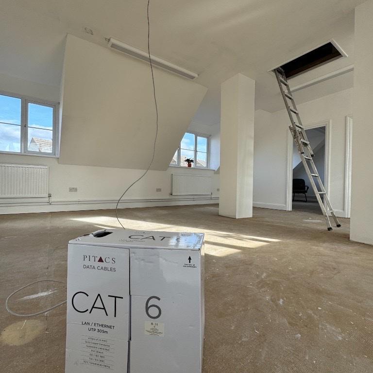 Cat6 data cable being pulled from a drum into a ceiling void during a home installation