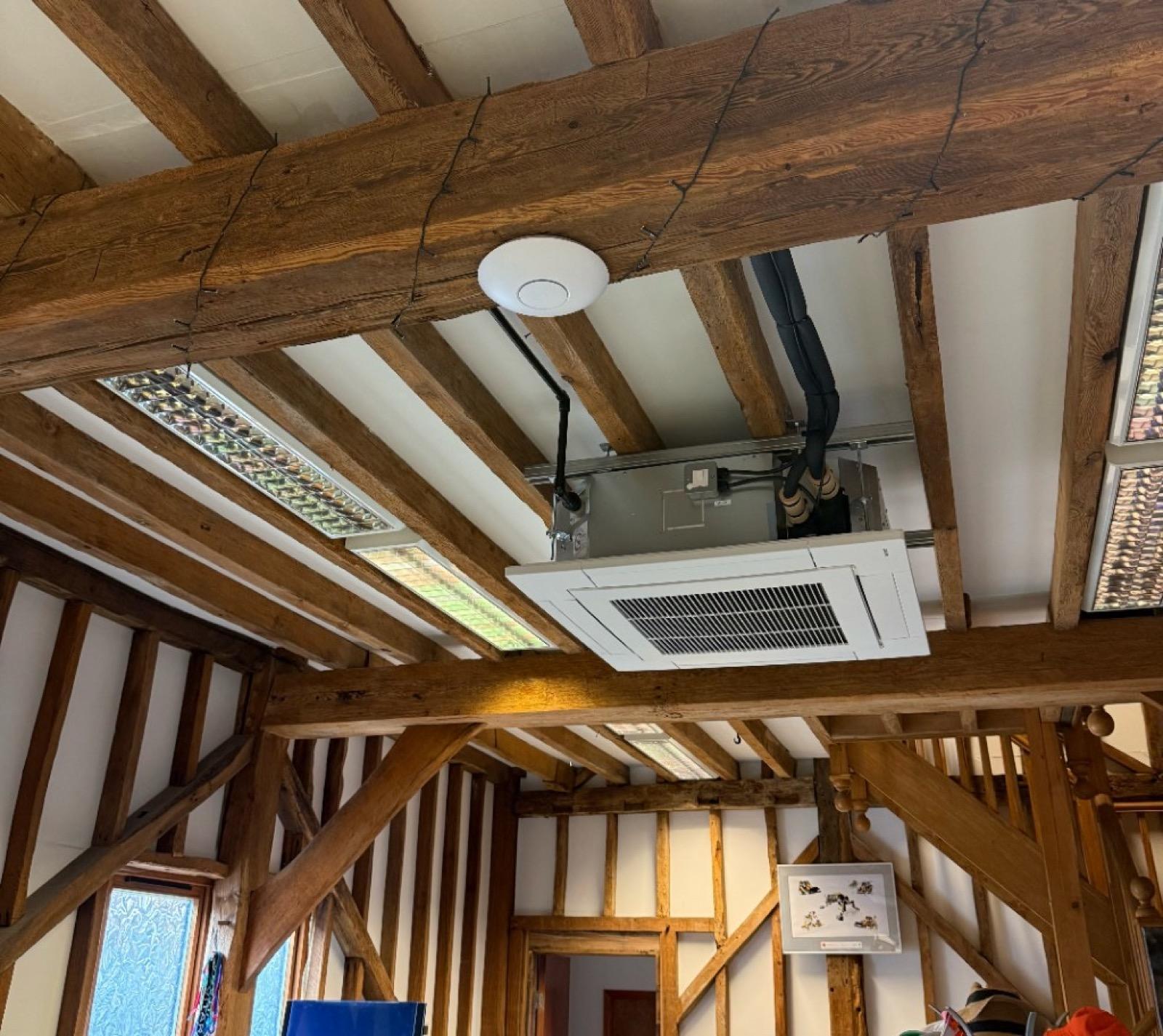 Business grade UniFi access point mounted on an exposed timber beam in a converted office