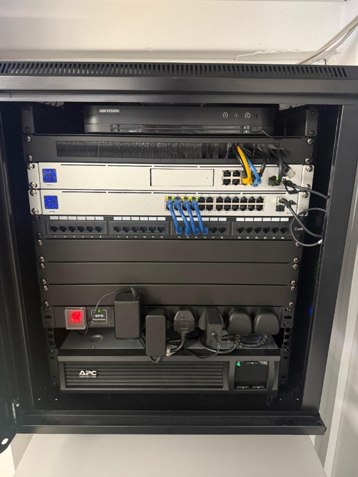 Professionally installed office network rack with UniFi gateway, switch, patch panel, NVR and UPS